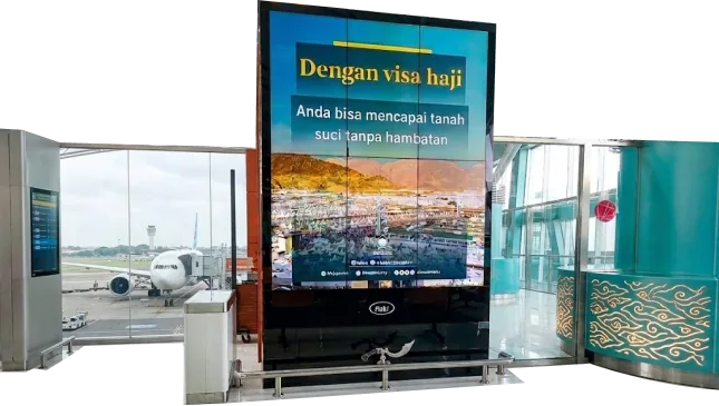 Saudi Tourism Hajj visa ad on an airport digital screen at Soekarno-Hatta Airport, Jakarta