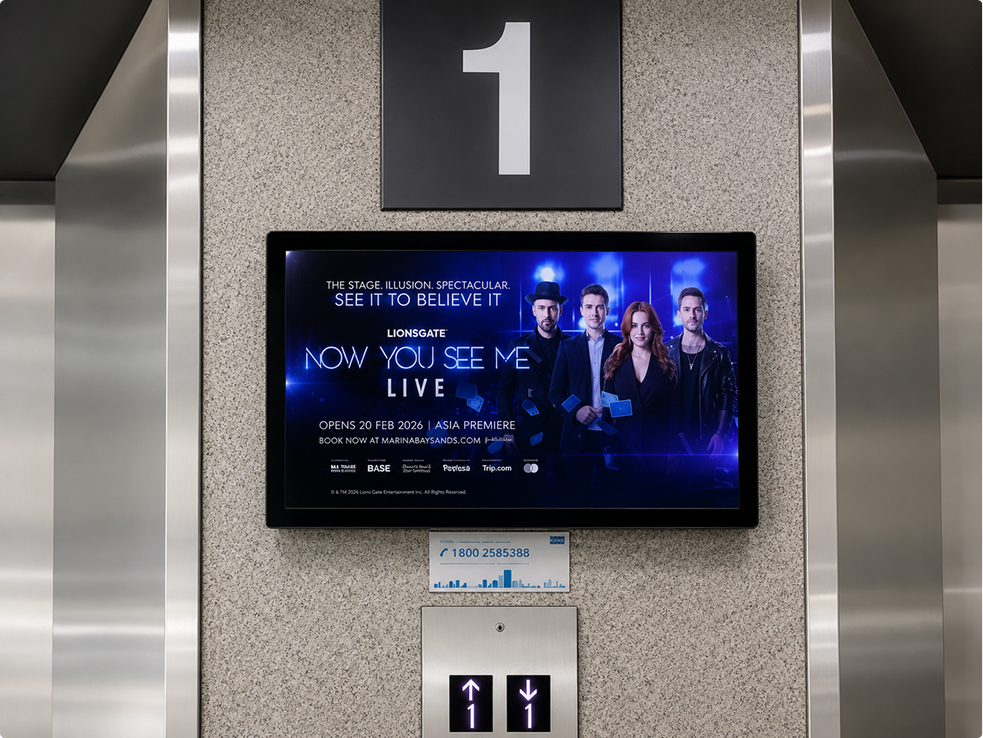 Office building lift lobby screen advertising a Now You See Me live show