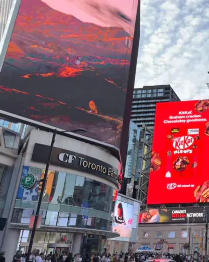 Korea Tourism and brand ads on LED billboards at a busy downtown intersection in Toronto, Canada