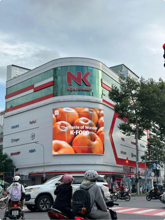 K-Food “The Taste of Wonder” fruit ad on a curved LED screen in Ho Chi Minh City, Vietnam