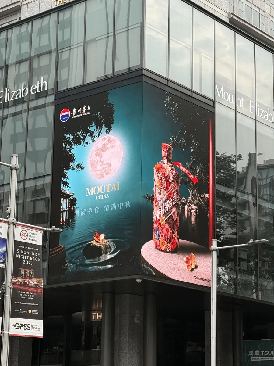 Moutai ad on a vertical LED screen on a building corner in Singapore